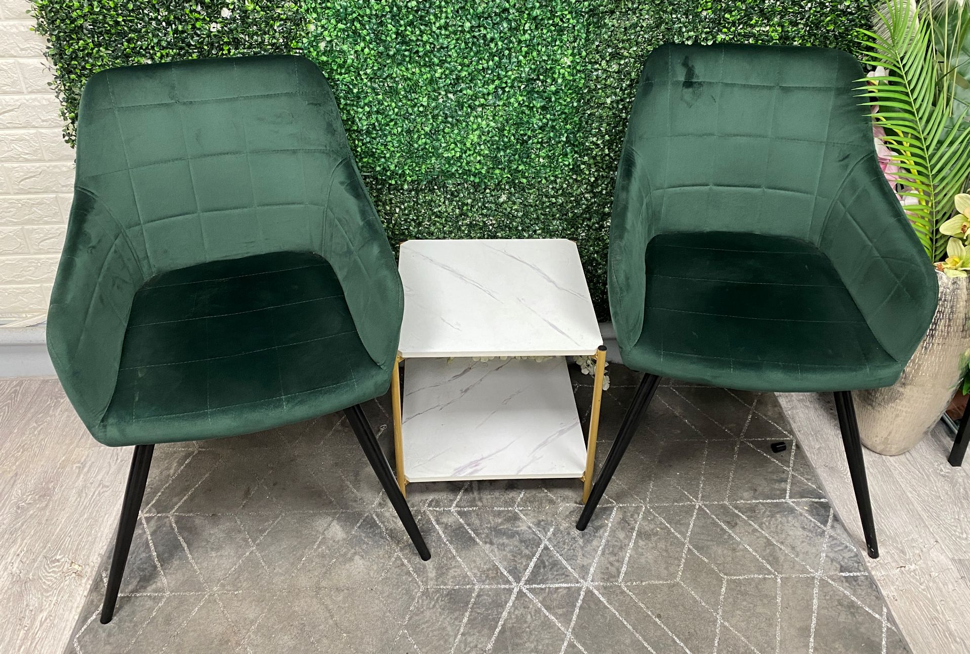 Two green reception chairs with small two-tier imitation marble side table.