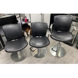 Three assorted black rexine adjustable styling chairs (one with broken arm) Further