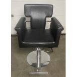 Barbers armchair in black rexine with rounded arms chrome side trail and front-operated pump action,