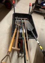 A wheelbarrow and contents comprising - post shovel, garden rakes and garden forks,