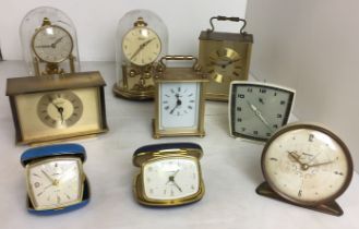 Box containing nine clocks including two quartz carriage clocks by Staiger (17cm high),