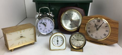 Green plastic box containing a barometer and five clocks including Smiths Tempora Sectronic brass