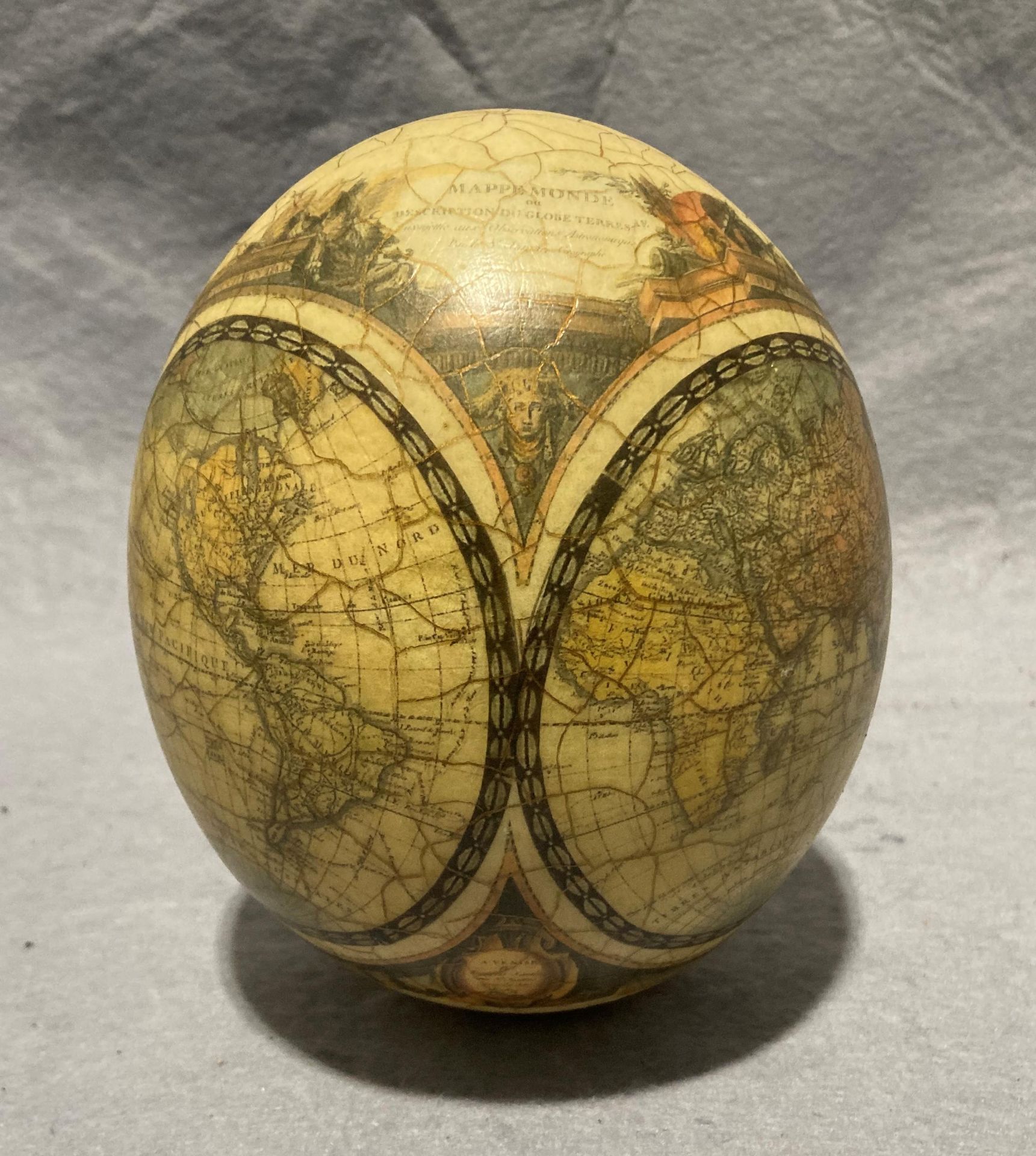 A decorated ostrich egg with World Map and Africa animal scene (approximately 16cm high) with a