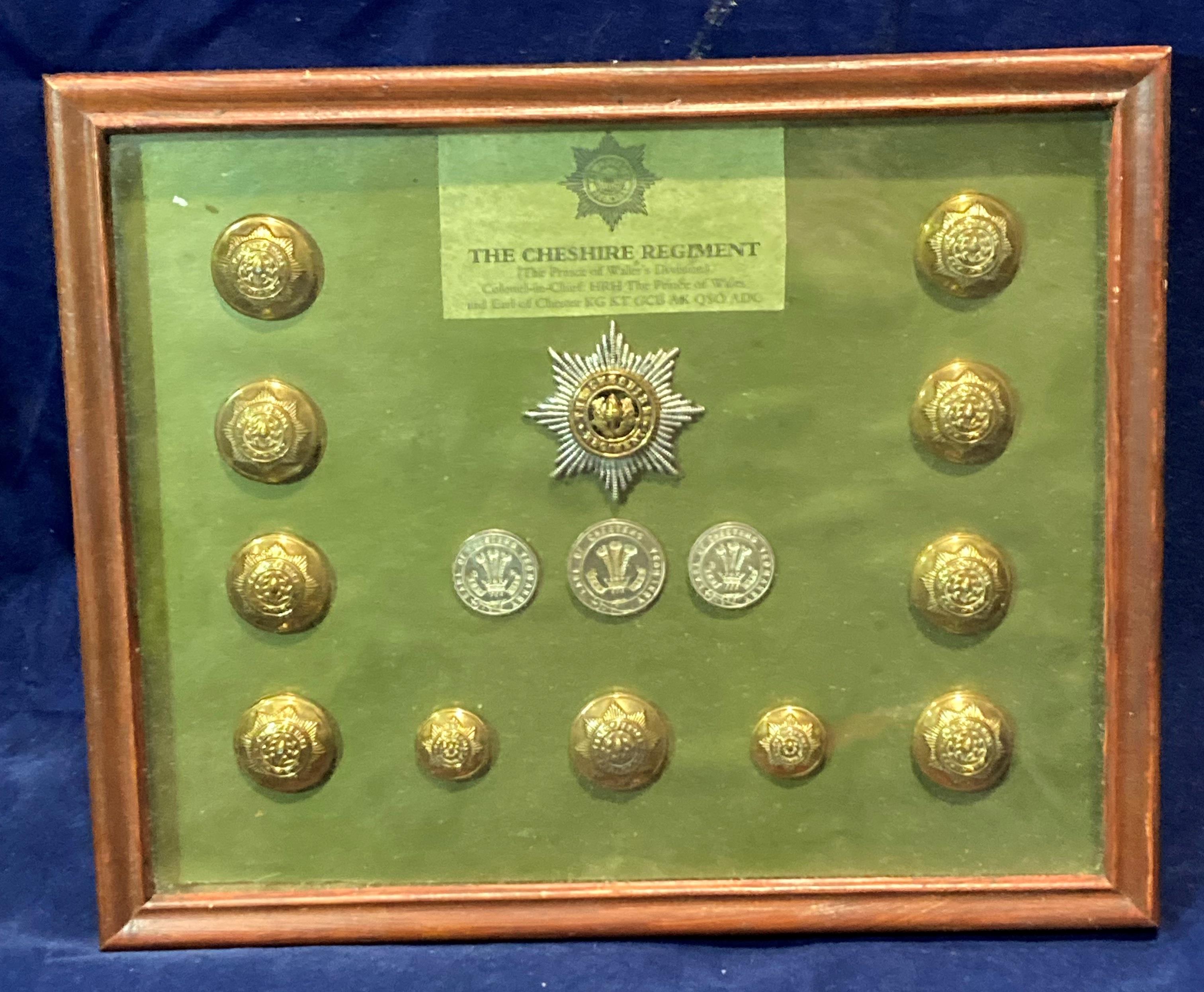A framed display of badges and buttons for the Cheshire Regiment with a list of battle honours to