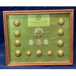 A framed display of badges and buttons for the Cheshire Regiment with a list of battle honours to