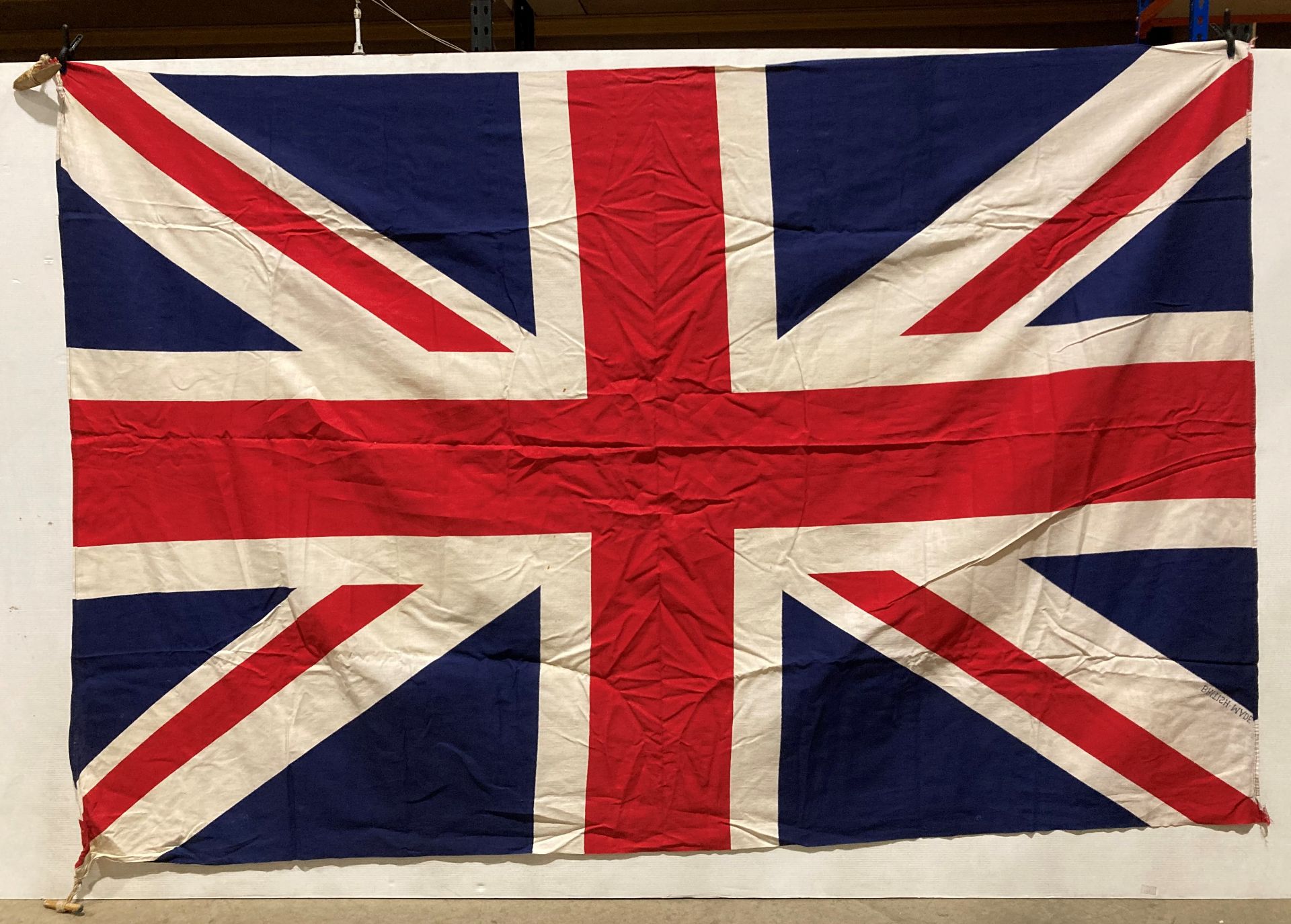 Union Jack flag with wooden pegs to two corners,