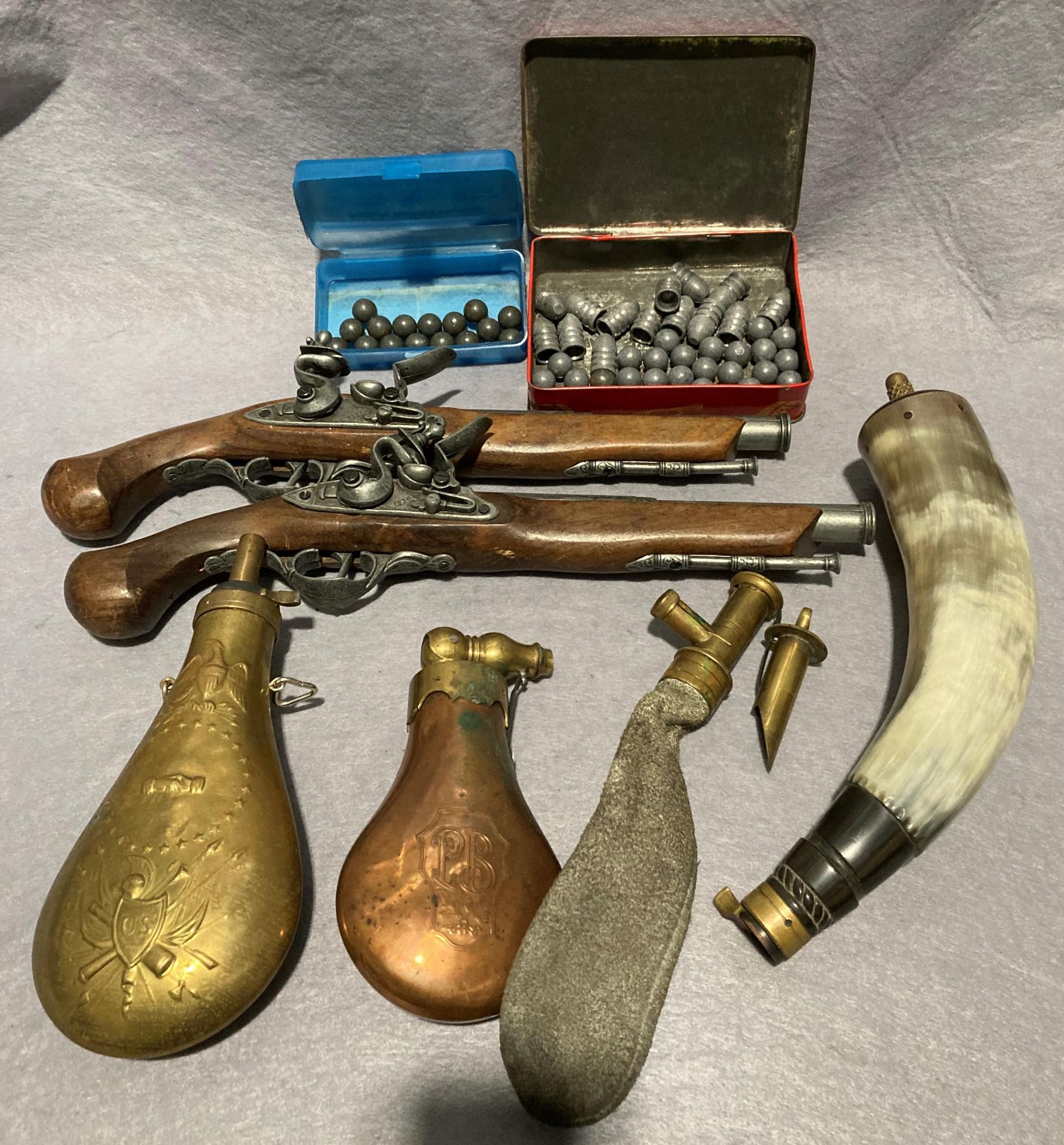 Contents to tray - two 1830 replica flintlock pistols, four assorted powder flasks including horn,