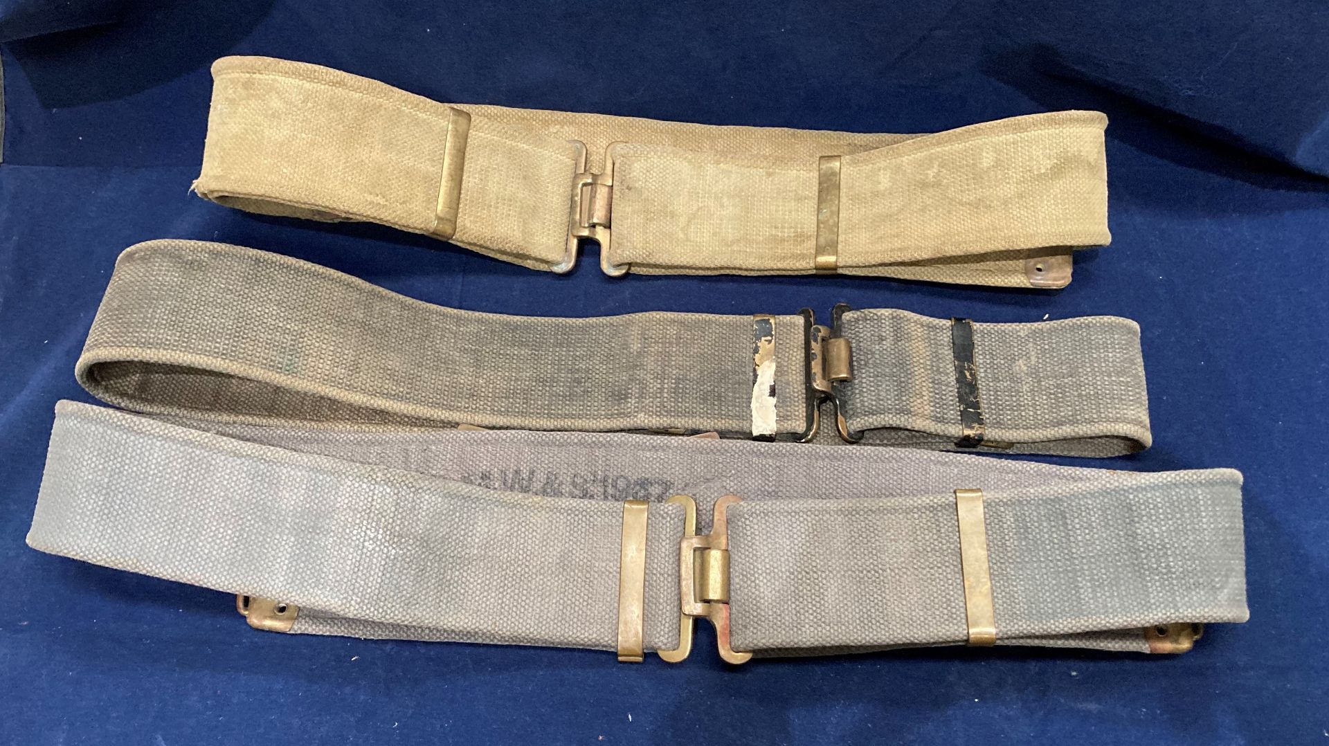 Two World War II British Army 37 pattern belts (one khaki and one grey) and a belt/utility strap