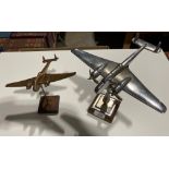 A chrome World War Two model aircraft, 25cm long, mounted on a chrome bomb and wood stand,