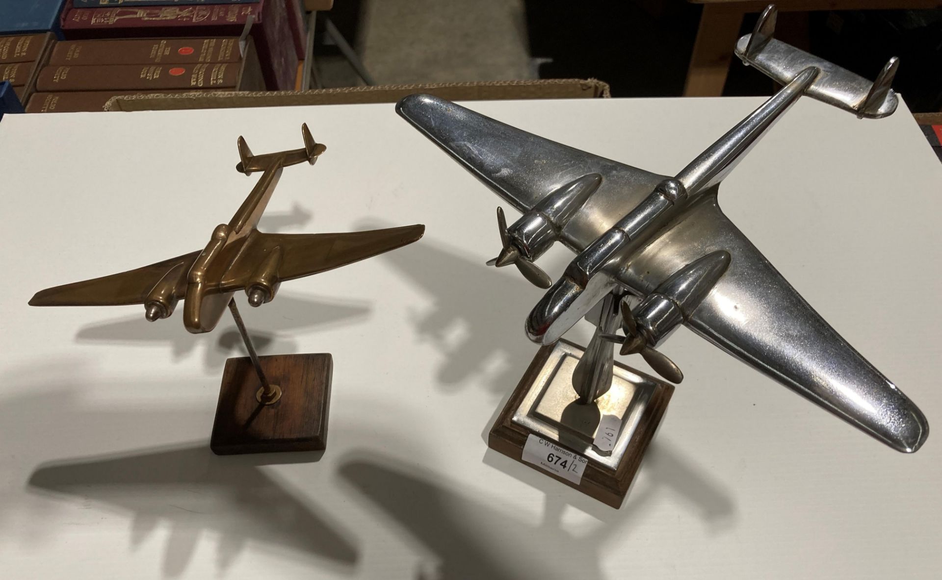 A chrome World War Two model aircraft, 25cm long, mounted on a chrome bomb and wood stand,