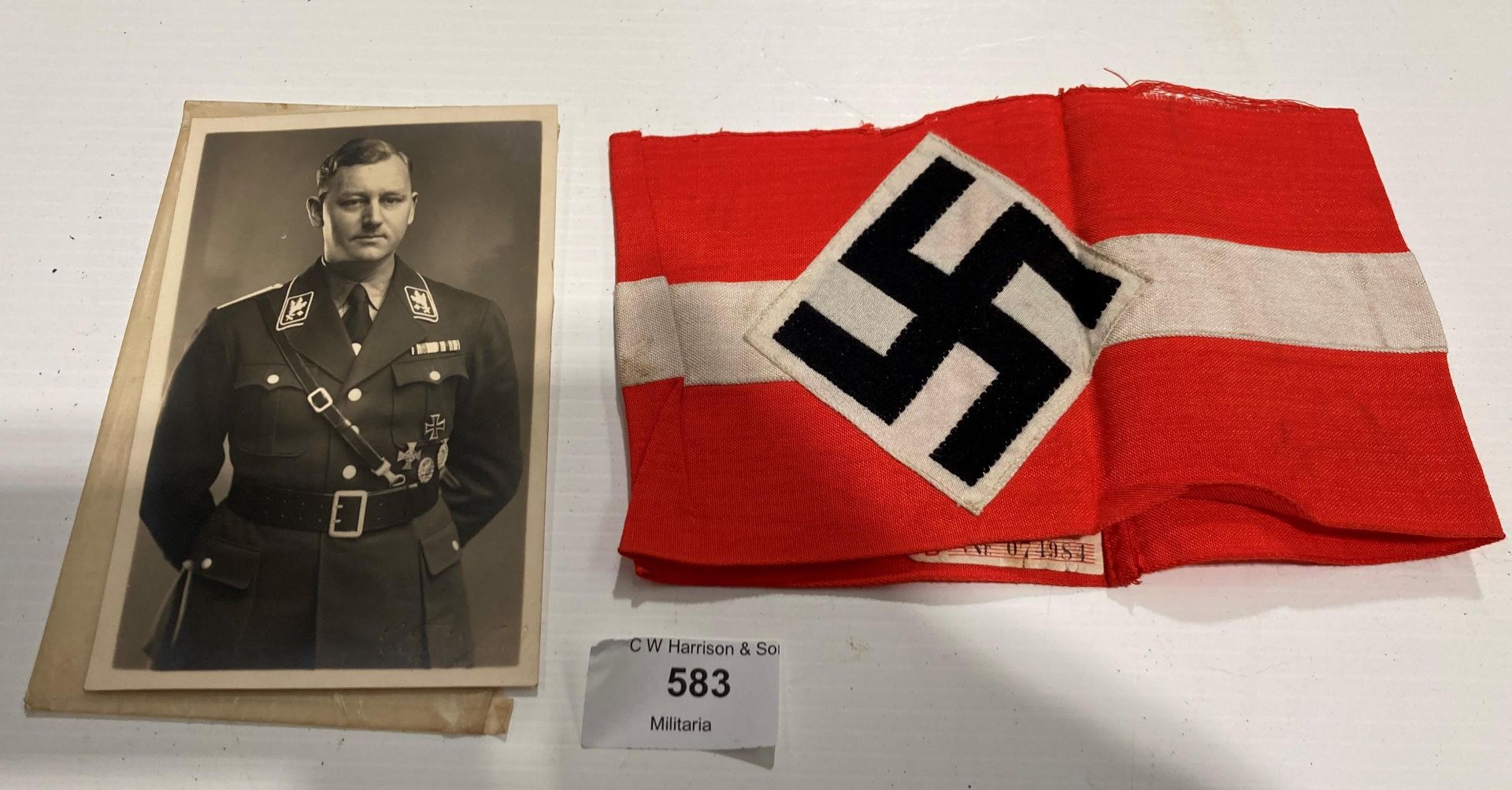 A German Second World War Swastika arm-band and a photograph of a German officer annotated to rear