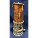 A copper and metal miner's lamp (glass missing), not named,