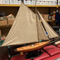 A large handmade pond yacht with three sails on a mahogany stand, hull size 90cm,