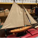 A large handmade pond yacht with three sails on a mahogany stand, hull size 90cm,