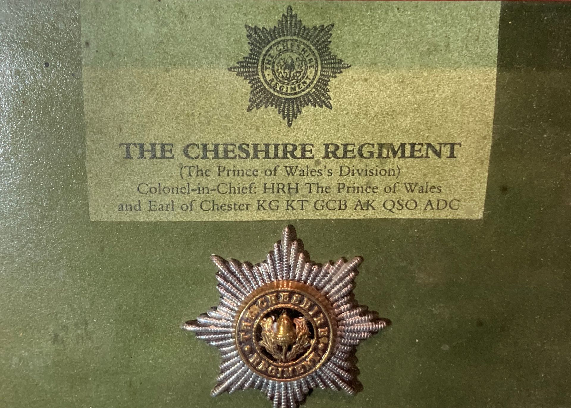 A framed display of badges and buttons for the Cheshire Regiment with a list of battle honours to - Image 2 of 3