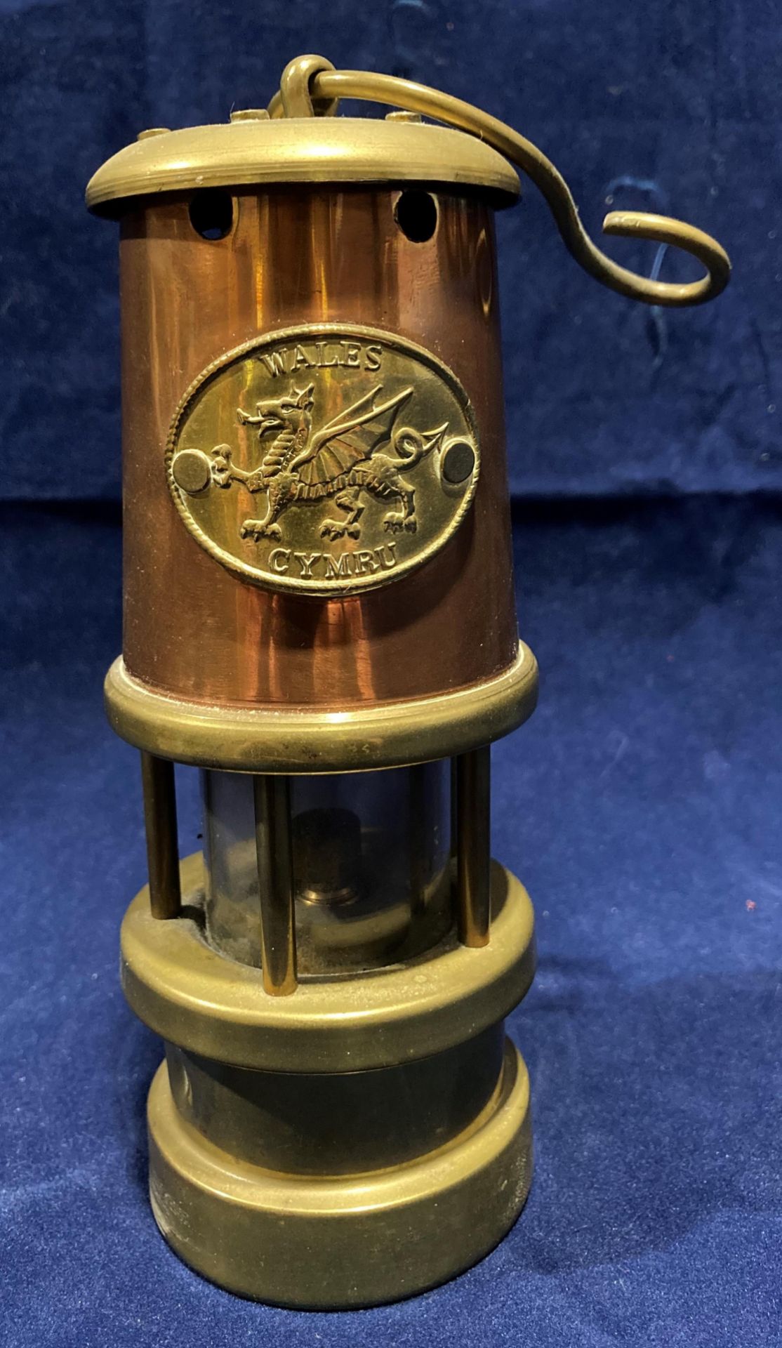 A brass and copper miniature model miner's lamp with Cymru Wales brass plate,