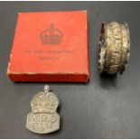 A silver ARP badge in box and a silver coloured napkin ring (2) (Saleroom location: S3 GC2)