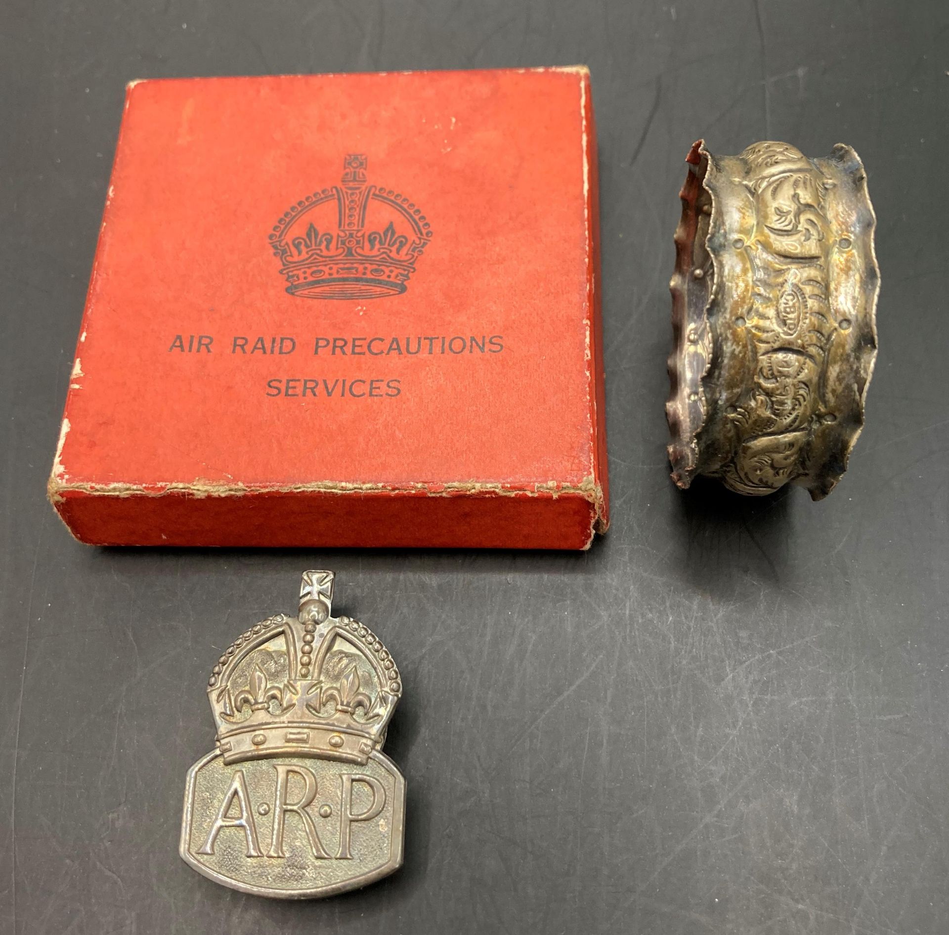 A silver ARP badge in box and a silver coloured napkin ring (2) (Saleroom location: S3 GC2)
