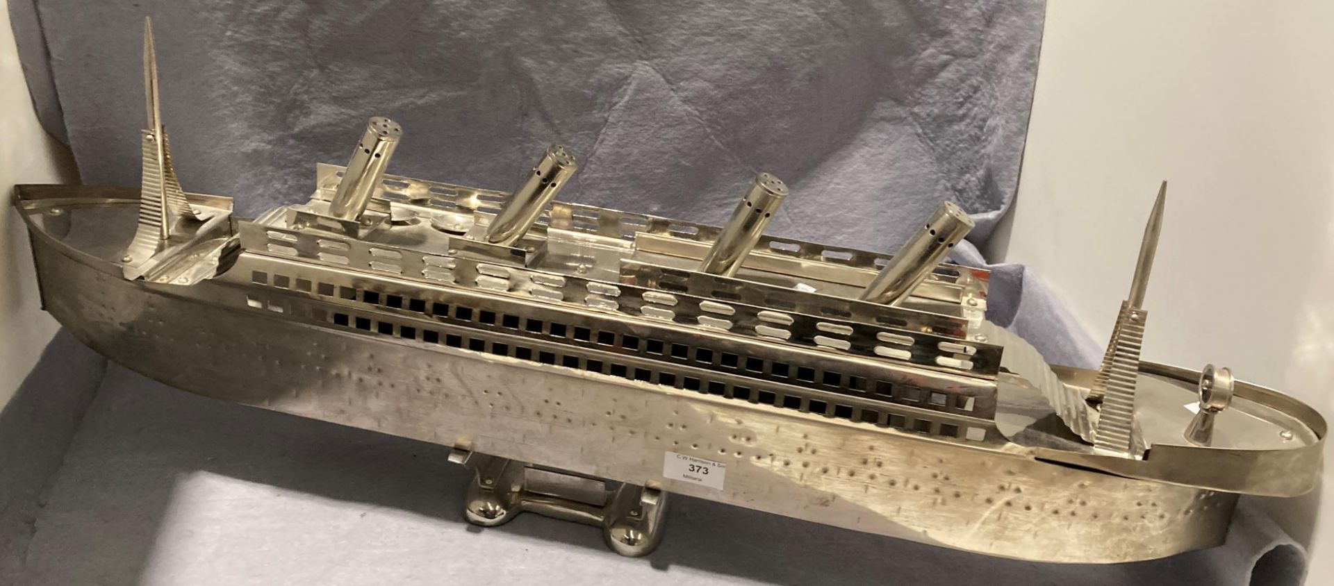 A modern metal model of a passenger liner on plinth,