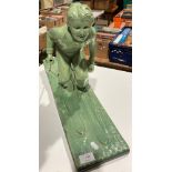 A green plaster sculpture of a female skier reg no: OP 428 RD 833044 on base (one stick broken),