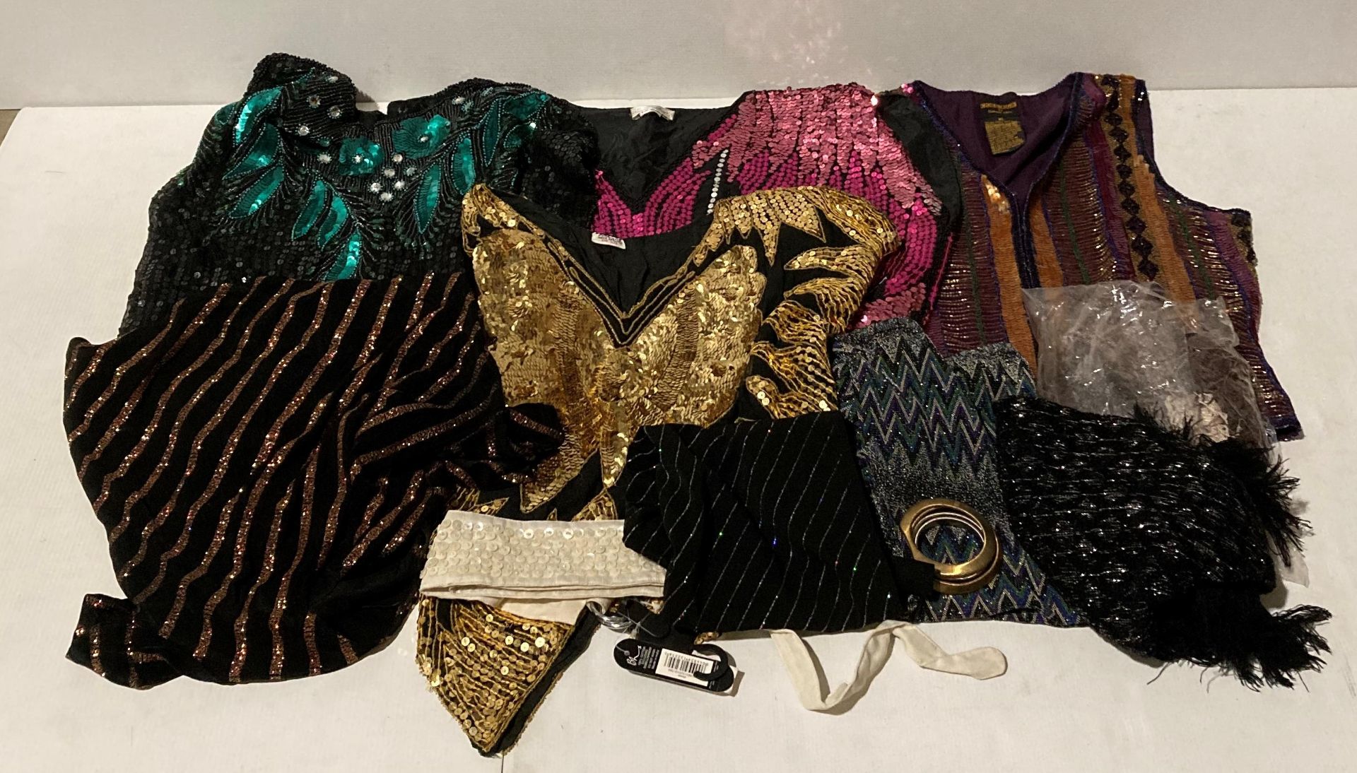An assortment of vintage clothing - sequin waistcoat and tops in a variety of colours,
