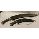 Two assorted sized Kukri knives with lions head and horn handles,