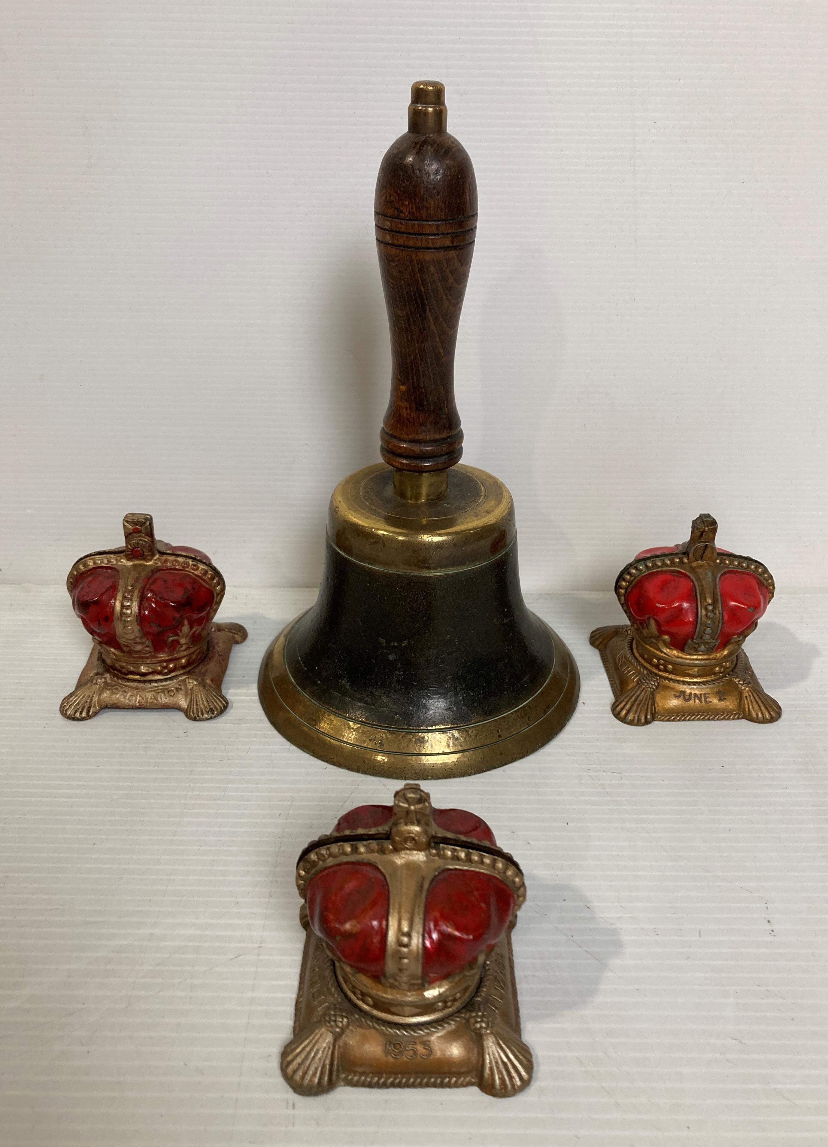 Four items including a vintage brass hand bell and three metal Elizabeth II crown money boxes
