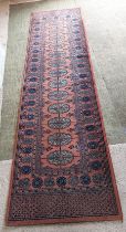 A pink and blue patterned oriental runner,