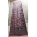 A pink and blue patterned oriental runner,