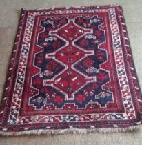 A red, blue and cream patterned oriental rug,