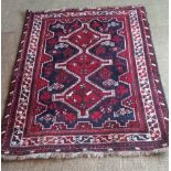 A red, blue and cream patterned oriental rug,