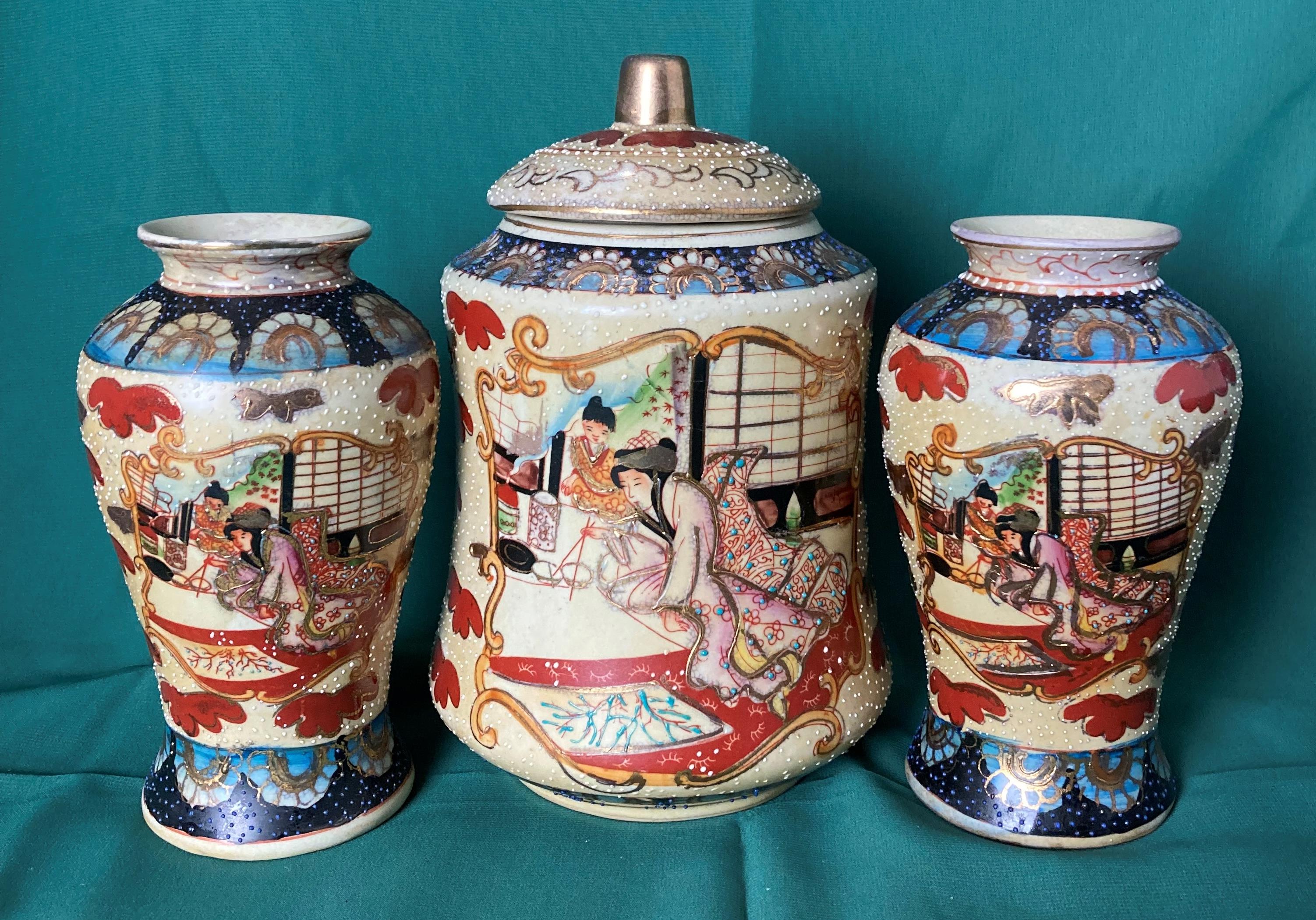 A Japanese Satsuma lidded jar with hand-painted Geishas and a matching pair of vases (saleroom