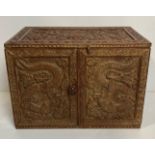 An Eastern hand-carved double-door table-top storage box with dragons to each door and floral