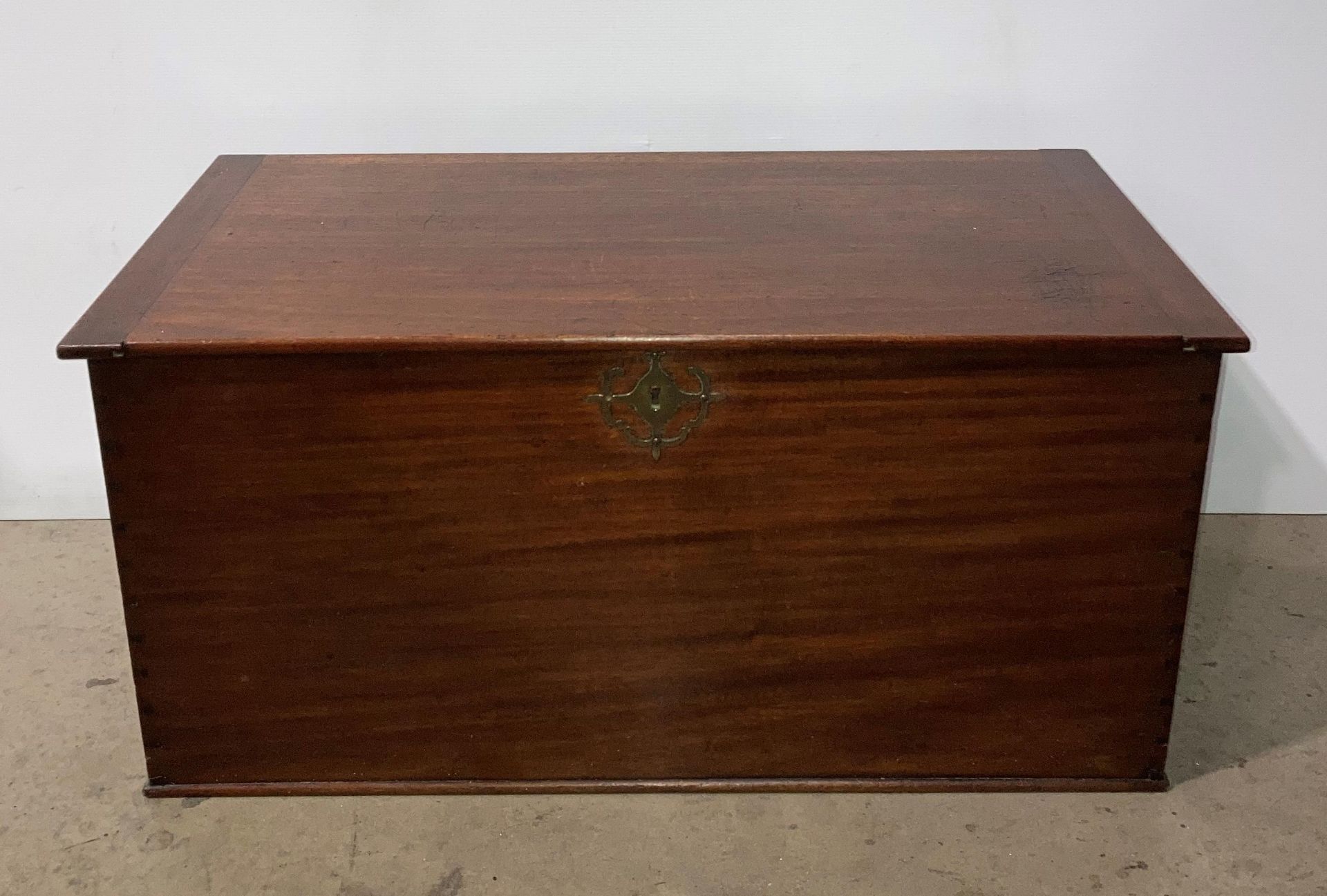 Mahogany lift-top storage chest with brass handles and brass key hole protector,