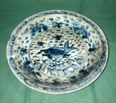 An antique Oriental blue and white glazed bowl with fish in pond to centre (bowl damaged and been