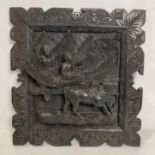 An ebonised Oriental hand-carved wall plaque with carved water buffalo and figures - some damages,