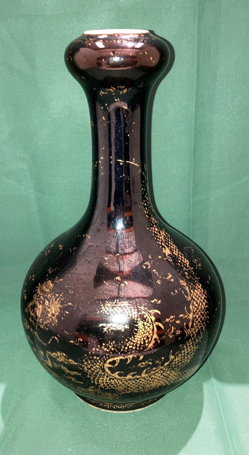 An early Kangxi black and gold dragon patterned vase with long neck and bud base with double circle