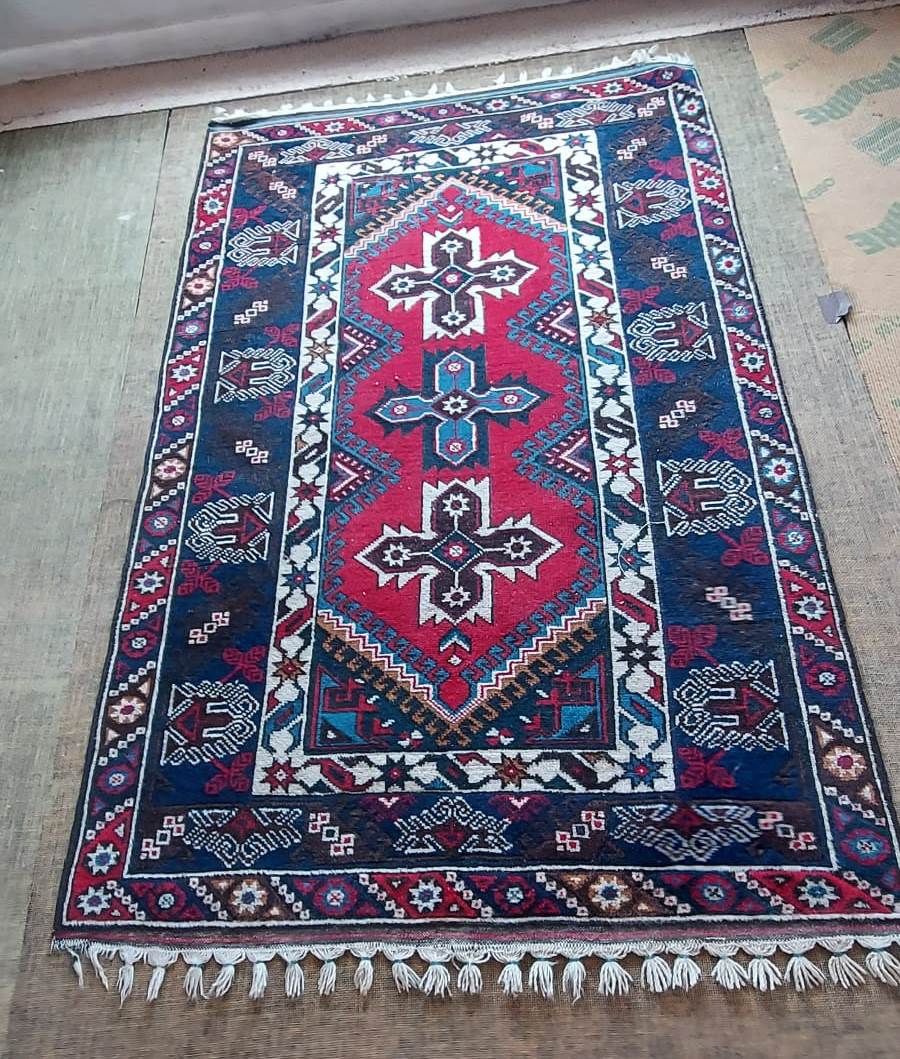 A Dosemalti red and blue patterned oriental rug,