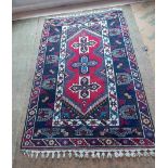 A Dosemalti red and blue patterned oriental rug,