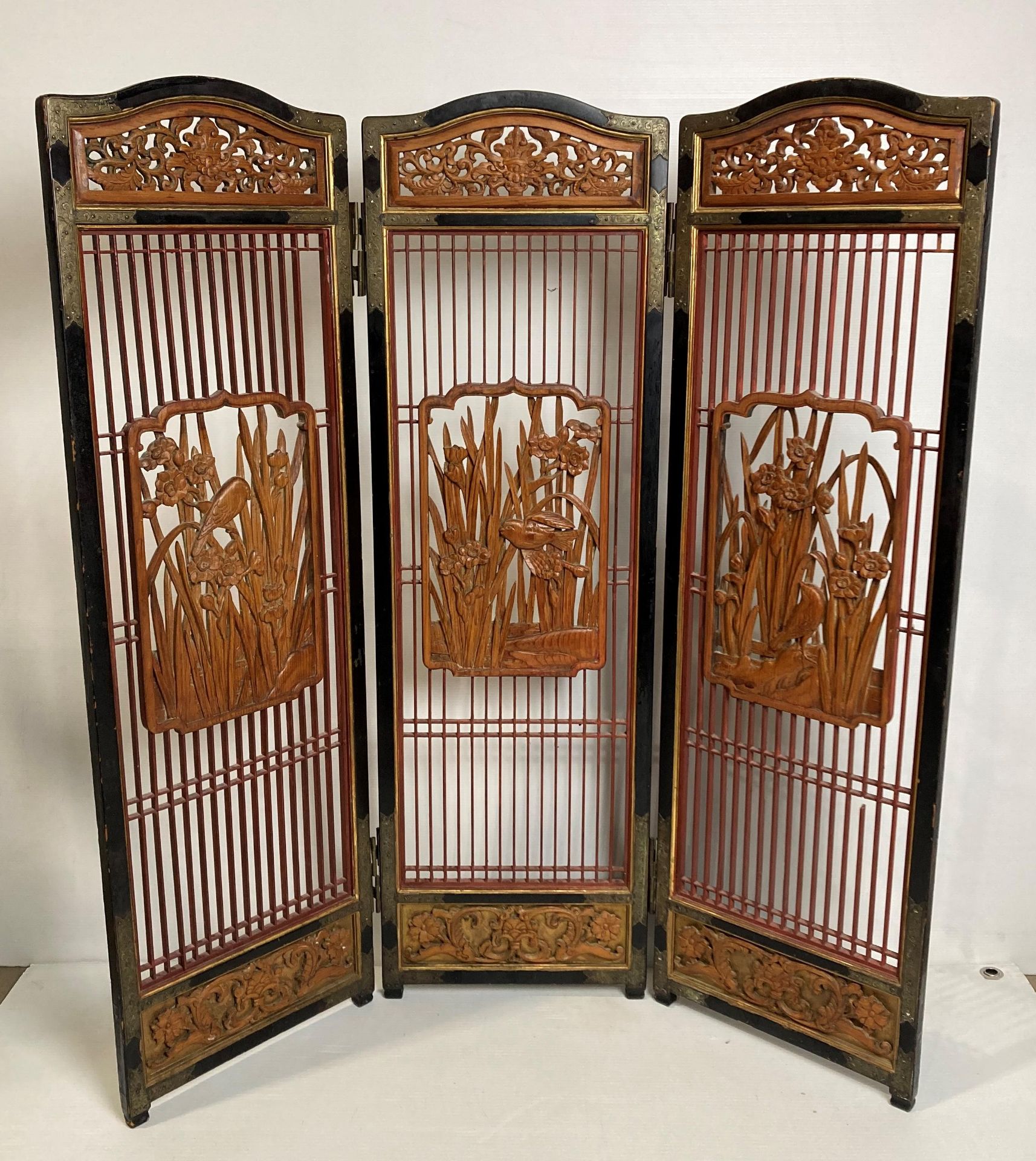 An Oriental wooden triple display screen with three hand-carved bird panels and etched detailed