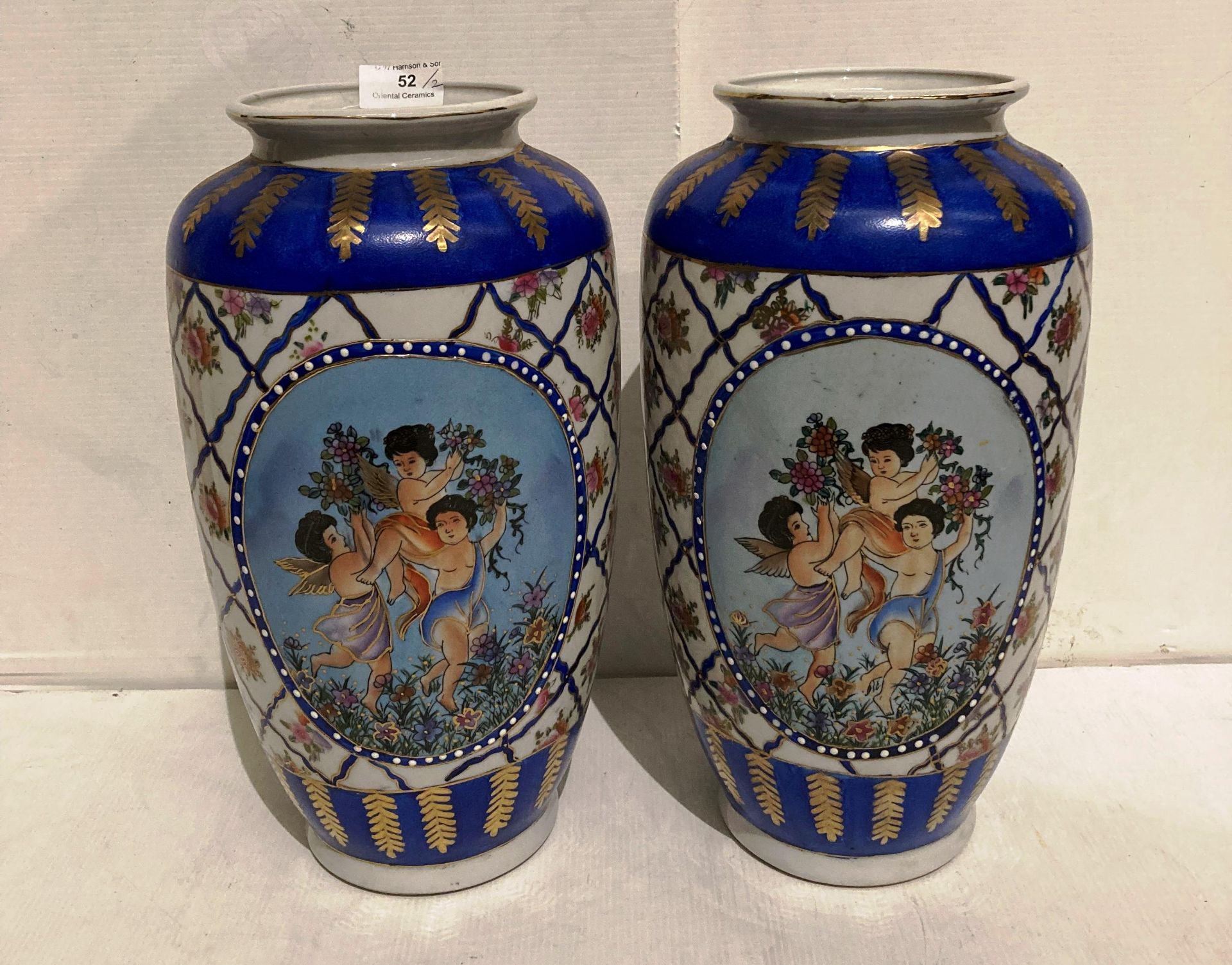 Pair of Oriental hand-painted vases (each 35cm high) painted with three winged cherubs (saleroom