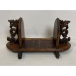 An oak Oriental table-top book rack with dragon ends,