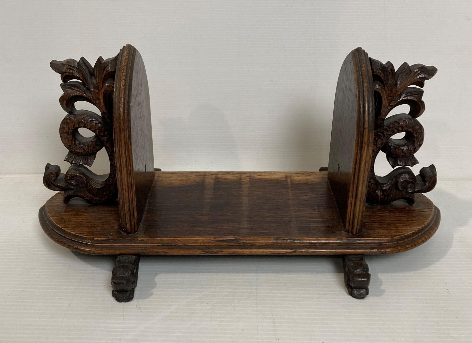 An oak Oriental table-top book rack with dragon ends,