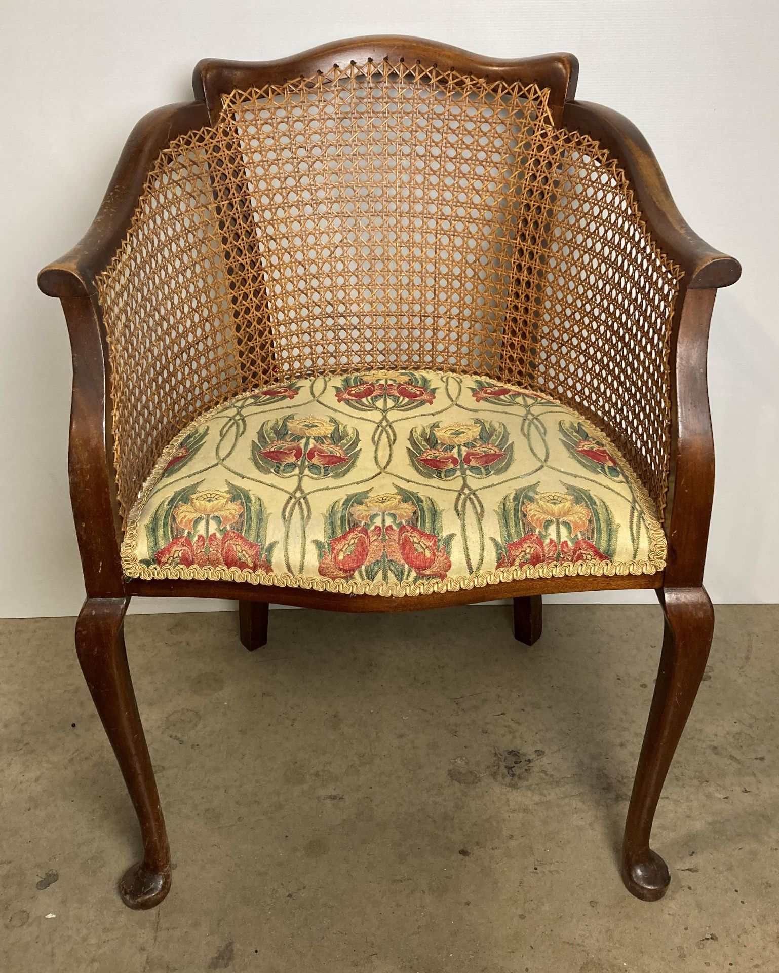 A vintage Bergère armchair with floral upholstered seat fabric (saleroom location: S2 QB13)
