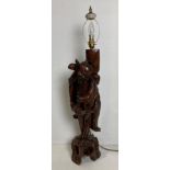 A wooden Oriental hand-carved table lamp with travelling man (no shade),