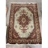 A green, brown and light brown patterned eastern rug with centre diamond pattern,