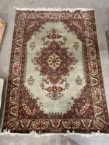 A green, brown and light brown patterned eastern rug with centre diamond pattern,