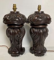 A pair of wooden heavily carved table lamps (no shades),