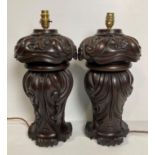A pair of wooden heavily carved table lamps (no shades),
