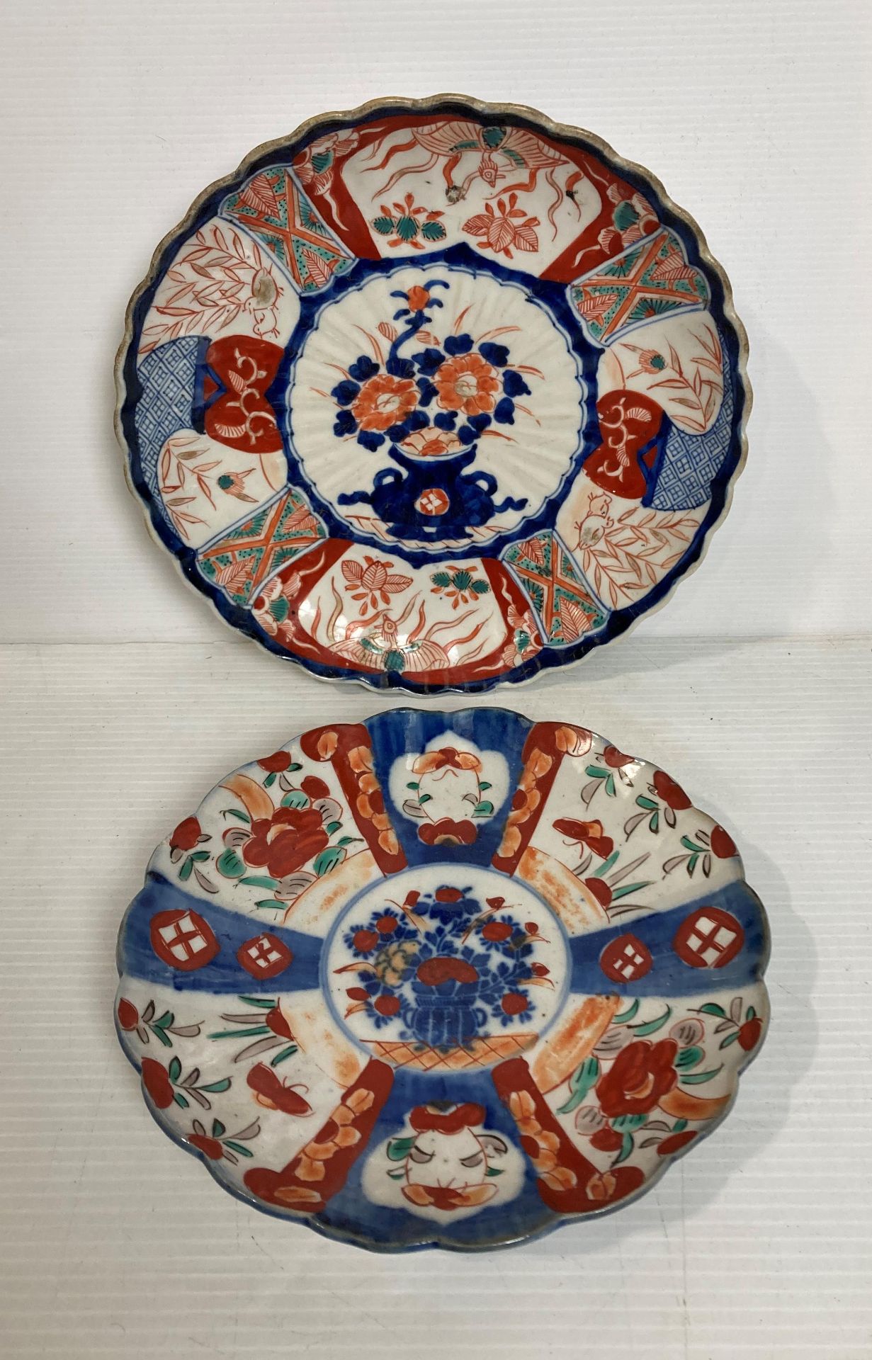 Two Oriental hand-painted Imari pattern scalloped plates, 21.5cm diameter and 24.